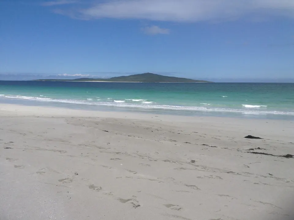 White sand and turquoise sea on the West Beach, with the island of Pabbay on the horizon